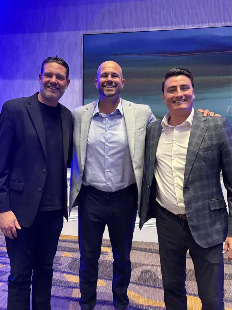 Three men in suits smiling and posing together at the San Diego Working Waterfront, Annual Dinner
